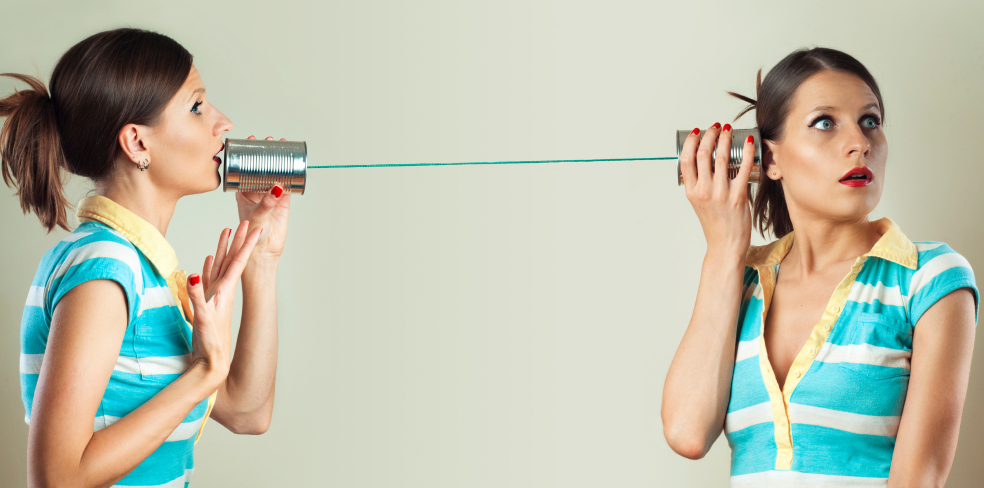 Two people communicating through tin cans connected by string — a metaphor for systems that need to talk to each other
